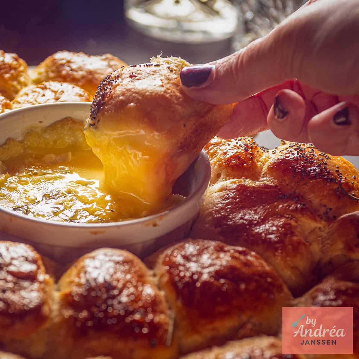 Een bolletje knoflookbrood gedipt in gesmolten camembert.