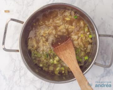 Een pan gevuld met prei, gestoofde kool, boter en bouillon.