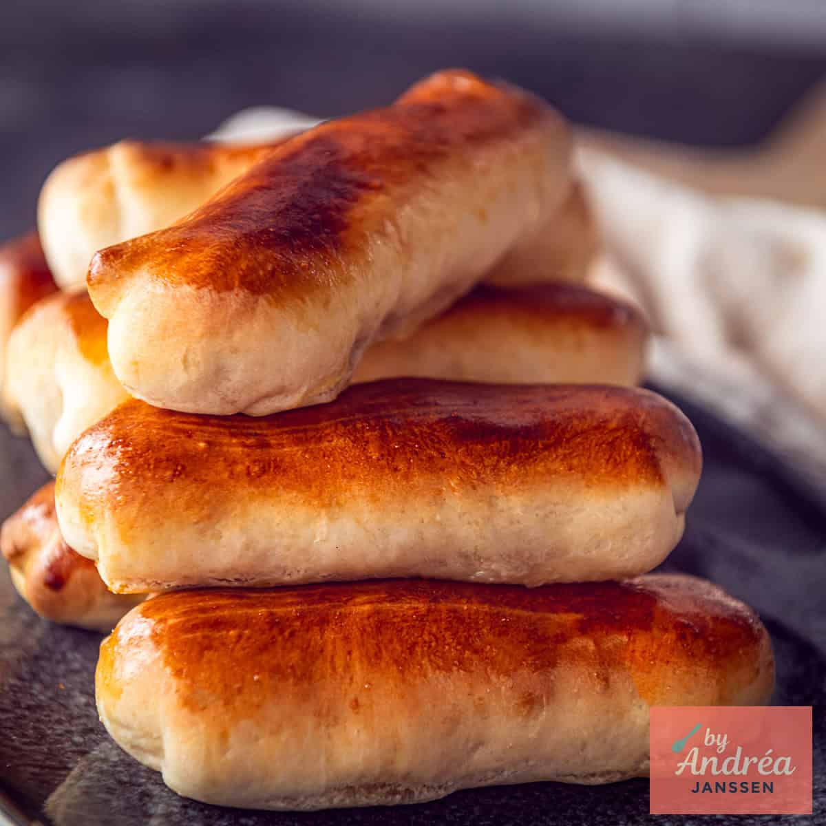 Een vierkante afbeelding met een deel van een bord met Brabantse worstenbroodjes.