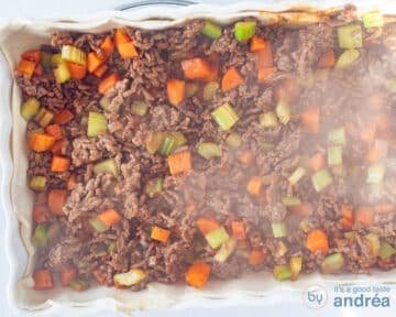 A white baking dish with puff pastry and a minced beef vegetable filling