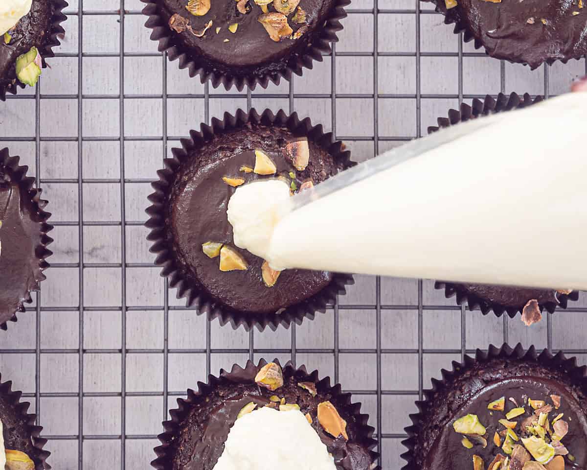 Met een spuitzak maak je een toefje chocolade bovenop de cupcake.