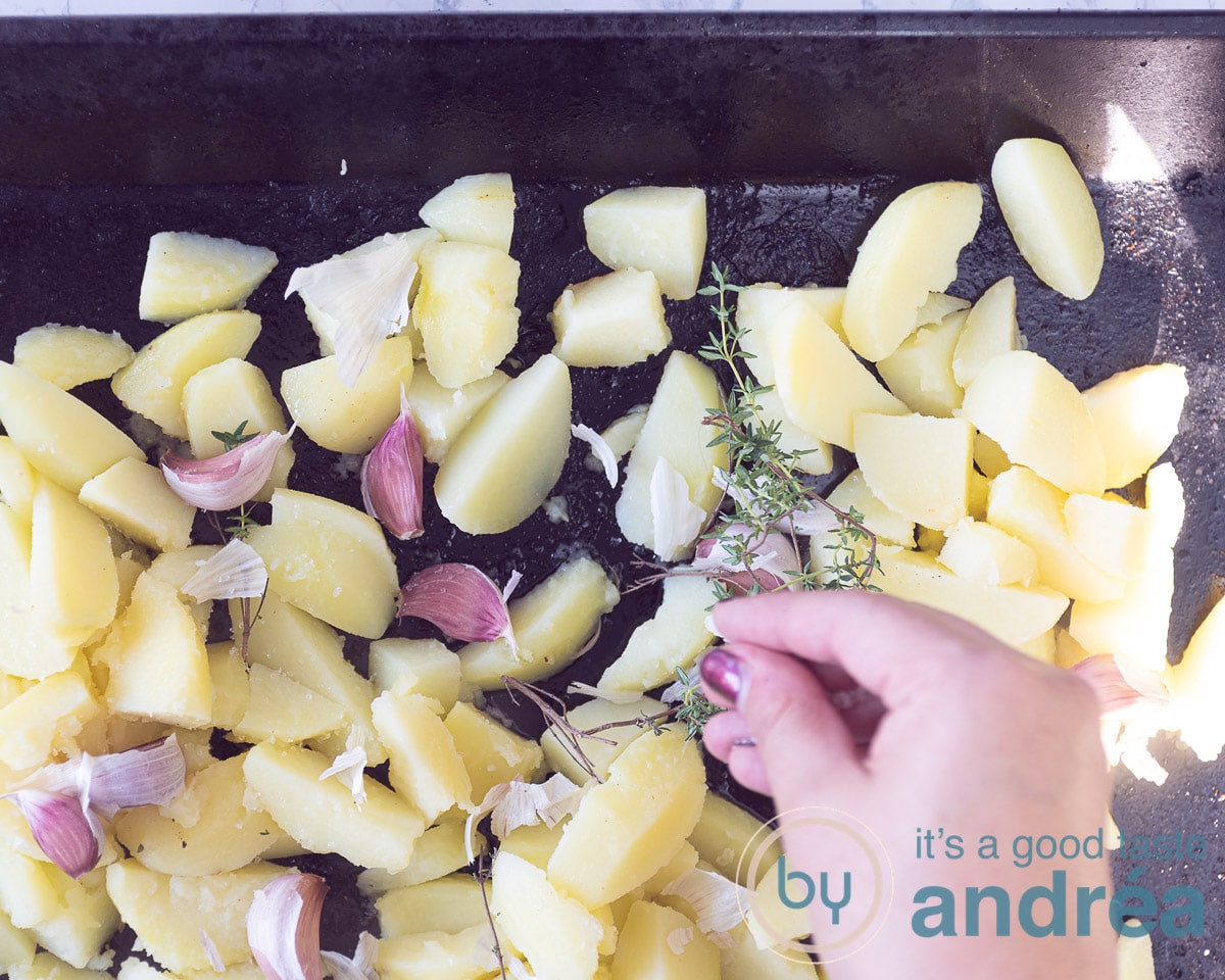 Verdeel de aardappelen met de knoflook en tijm over de bakplaat