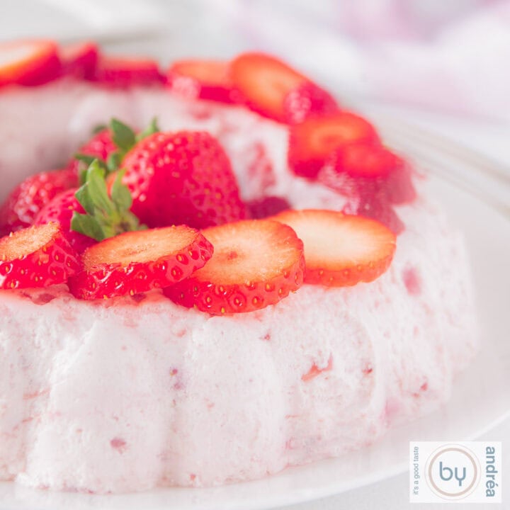 Een vierkante foto met zelfgemaakte aardbeienbavarois met verse aardbeien.
