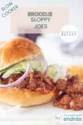 Een bolletje met sloppy joe, rode ui en salade. Een tekst bovenin: slowcooker, makkelijk recept, broodje sloppy joes.