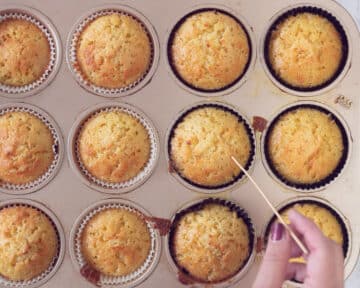 Een cupcake vorm met gebakken cupcakes. Een prikker die erin steekt.