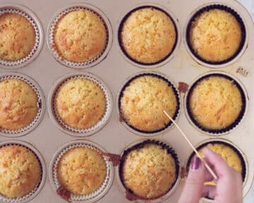 Een cupcake vorm met gebakken cupcakes. Een prikker die erin steekt.