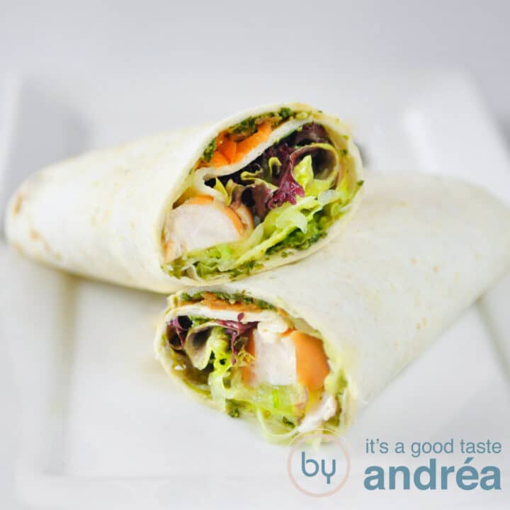 a square photo with two wraps filled with smoked chicken, salad, carrots and cucumber