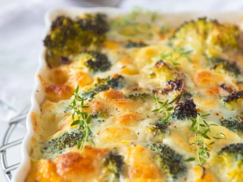 a white casserole dish filled with frittata with mozzarella and broccoli. A sppon in the background