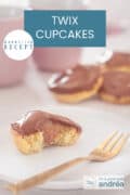 Een halve Twix cupcake met cake, karamel en chocola. In de achtergrond meer cupcakes. Een tekst bovenin: makkelijk recept, Twix Cupcakes
