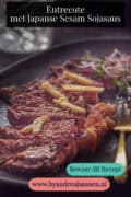 Een zwart bord met entrecote reepjes, gember en een heerlijke saus. Tekst: entrecote met Japanse Sesam Sojasaus