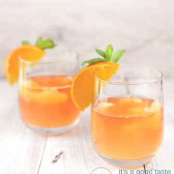 2 glazen met oranje cocktail en een schijfje sinaasappel