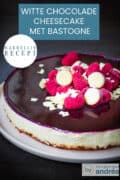 Een deel van een witte chocola Bastogne bosvruchten cheesecake op een donkere achtergrond. Een tekst: witte chocolade cheesecake met bastogne, makkelijk recept