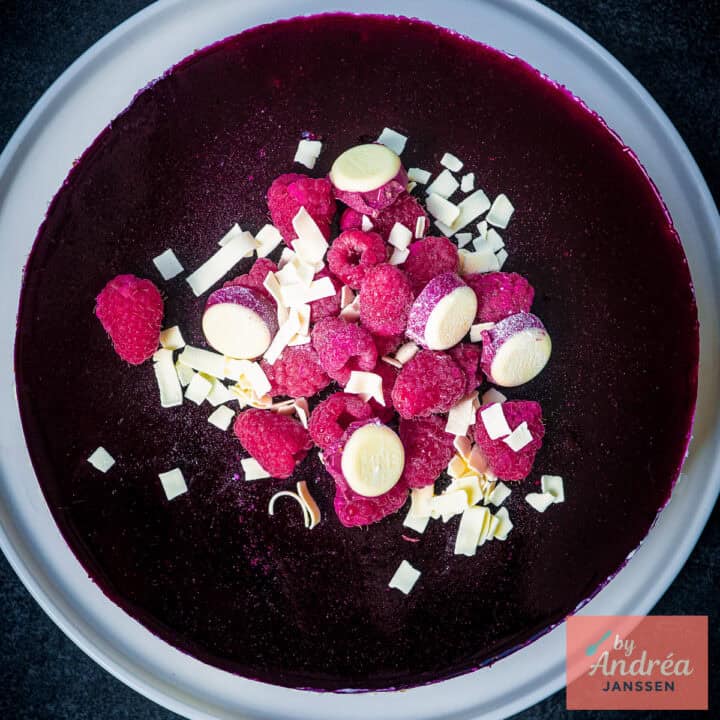 A square picture of a no bake cheesecake with white chocolate and forrest fruits.