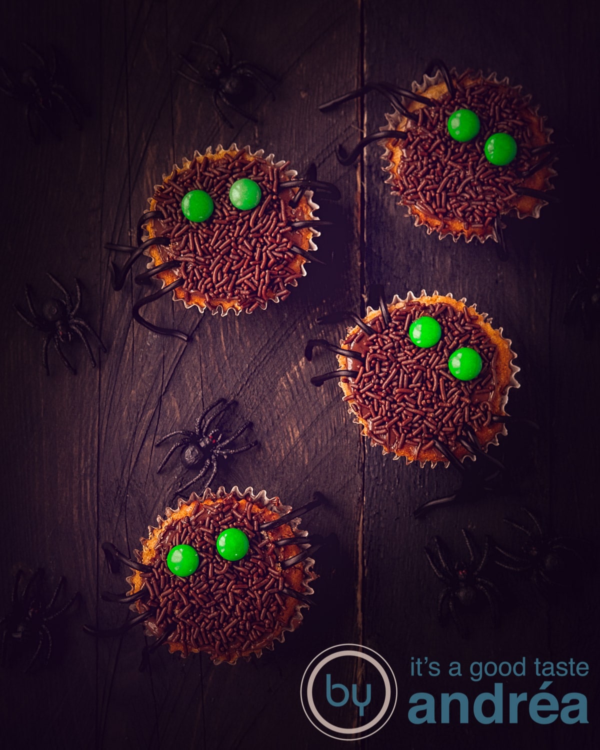 4 Halloween cupcakes op donkere planken met spinnen er tussen