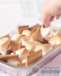 een hand pakt een s'more uit het aluminium bakje