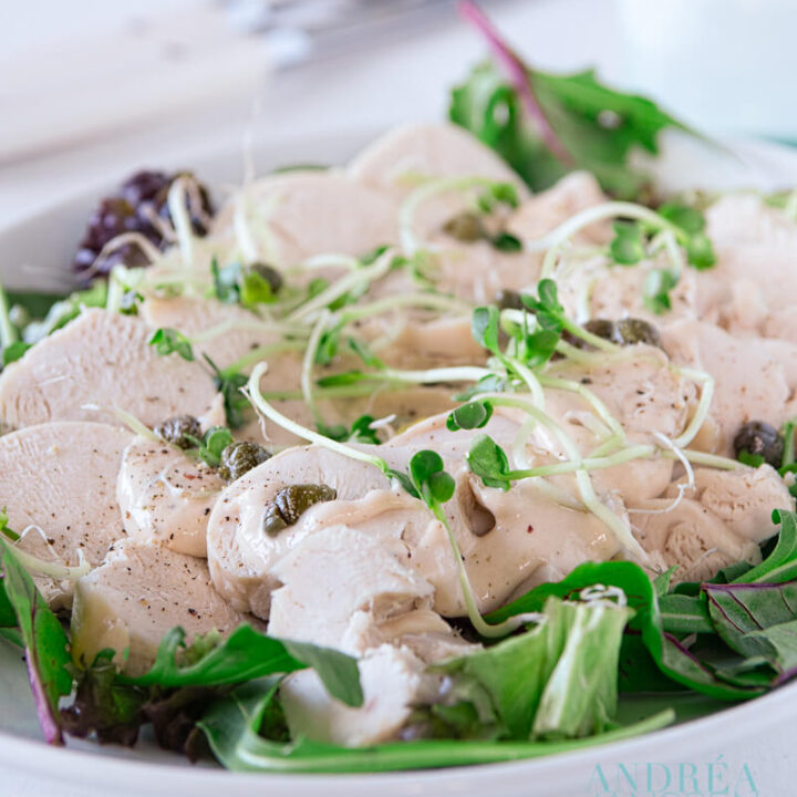 delicious turkey vitello tomato on a white plate with green salad