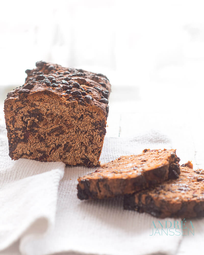 een half krenten en cranberry brood met losse plakjes op een wit doek