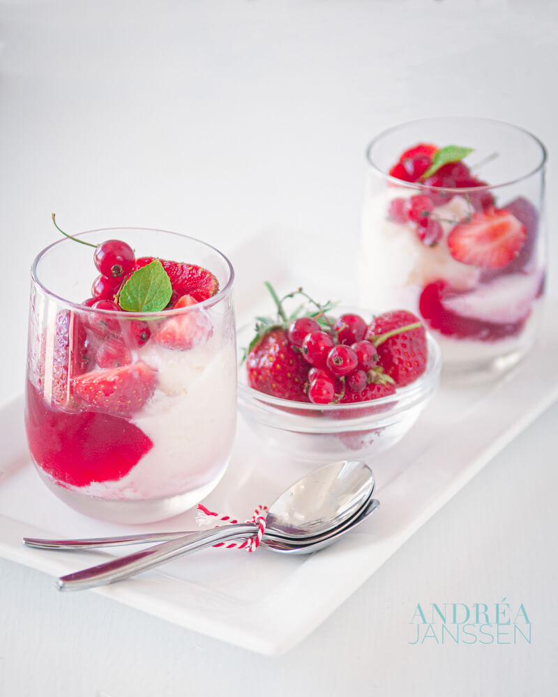 2 glaasjes met frozen yoghurt jam en rood fruit garnering en een bakje rood fruit.