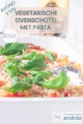 Een deel van een witte ovenschaal gevuld met een pasta caprese ovenschotel. Een tekst bovenin avondeten, vegetarische ovenschotel met pasta, makkelijk recept.