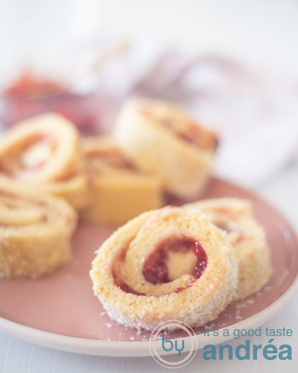 Aardbeien cake rolletjes op een roze bord met een witte achtergrond