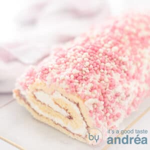 Een vierkante foto met een deel van een baby shower cake rol op een glazen plaat.