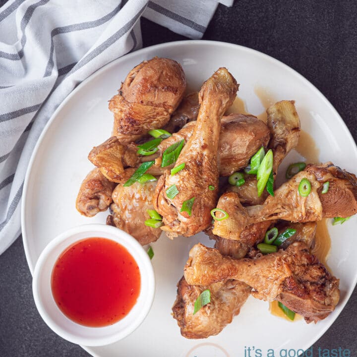 een bord met kip drumsticks in soja saus en een kommetje met chilisaus