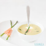 een schaal met een kom mosterden en groene asperges met zalm