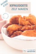 Een halve roze schaal gevuld met bakpapier en kipnuggets. Een witte ondergrond. Een tekstoverlay kipnuggets zelf maken avondeten, makkelijk recept, kip