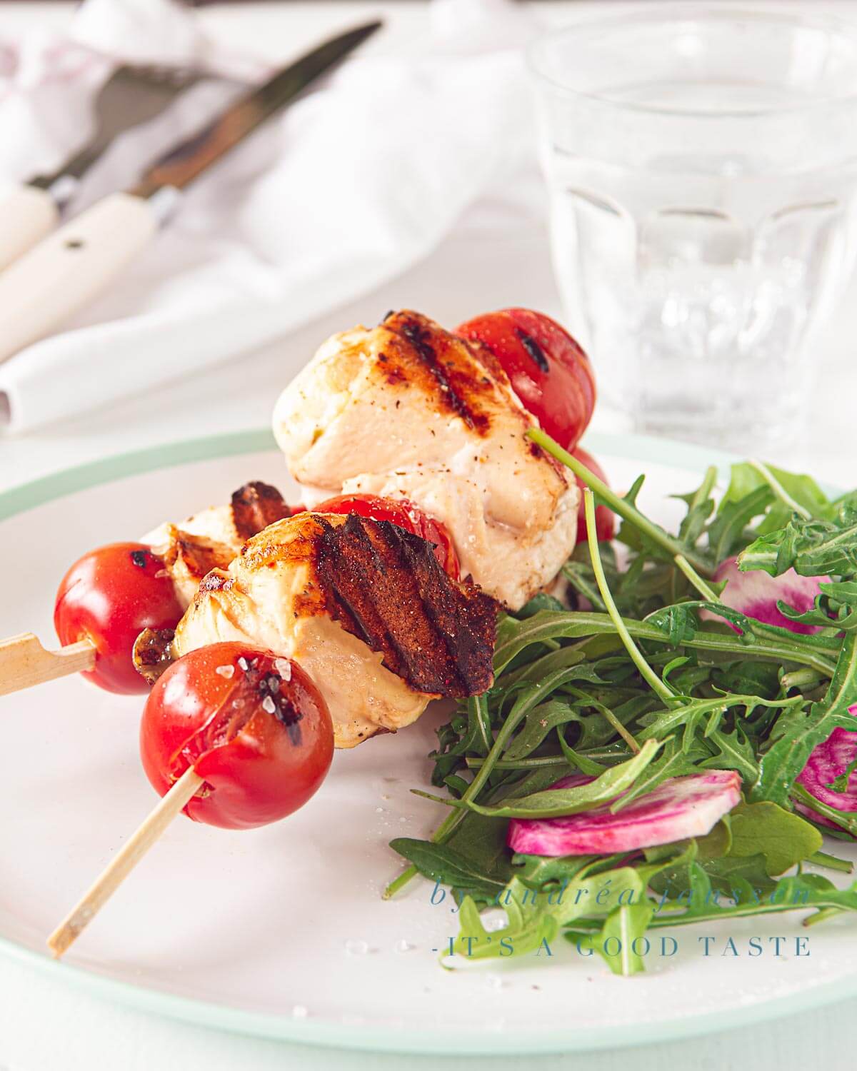 een bord met twee kip mozzarella spiesjes een een salade