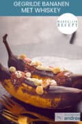 Twee bananen op een houten plank met marshmallows, whisky en chocola. Een tekst bovenin: makkelijk recept, gegrilde bananen met whisky