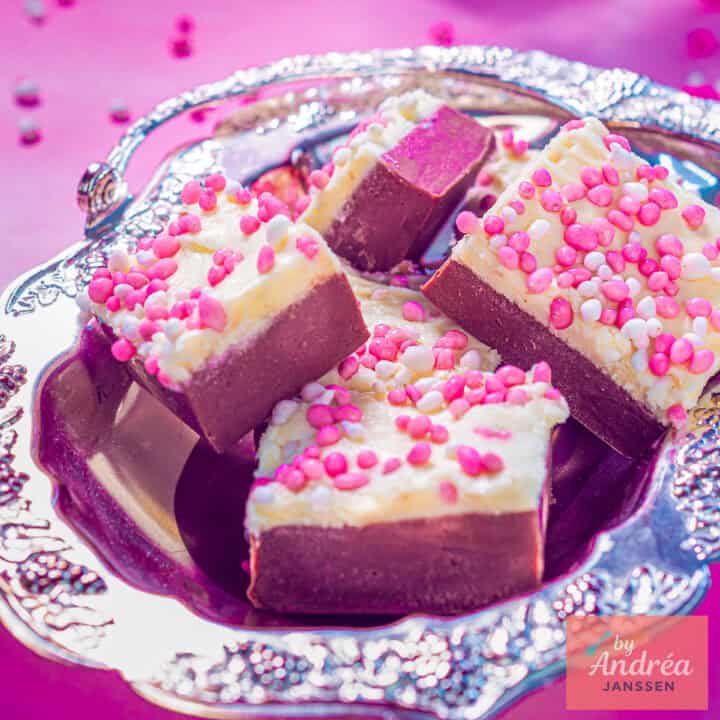 Een vierkante foto met een zilveren schaal met fudge met muisjes