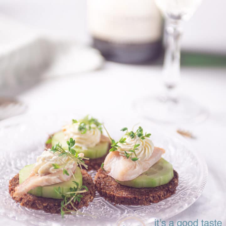 3 gerookte forel hapjes met zure room, champagne op de achtergrond