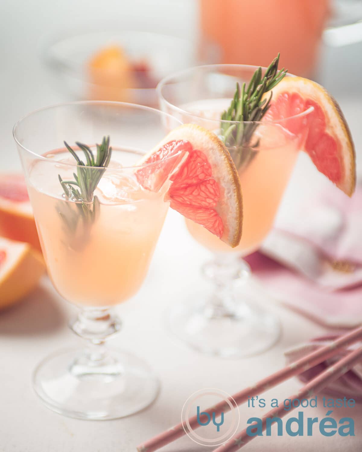 Twee glazen grapefruit mocktail met rietjes en andere accesoires