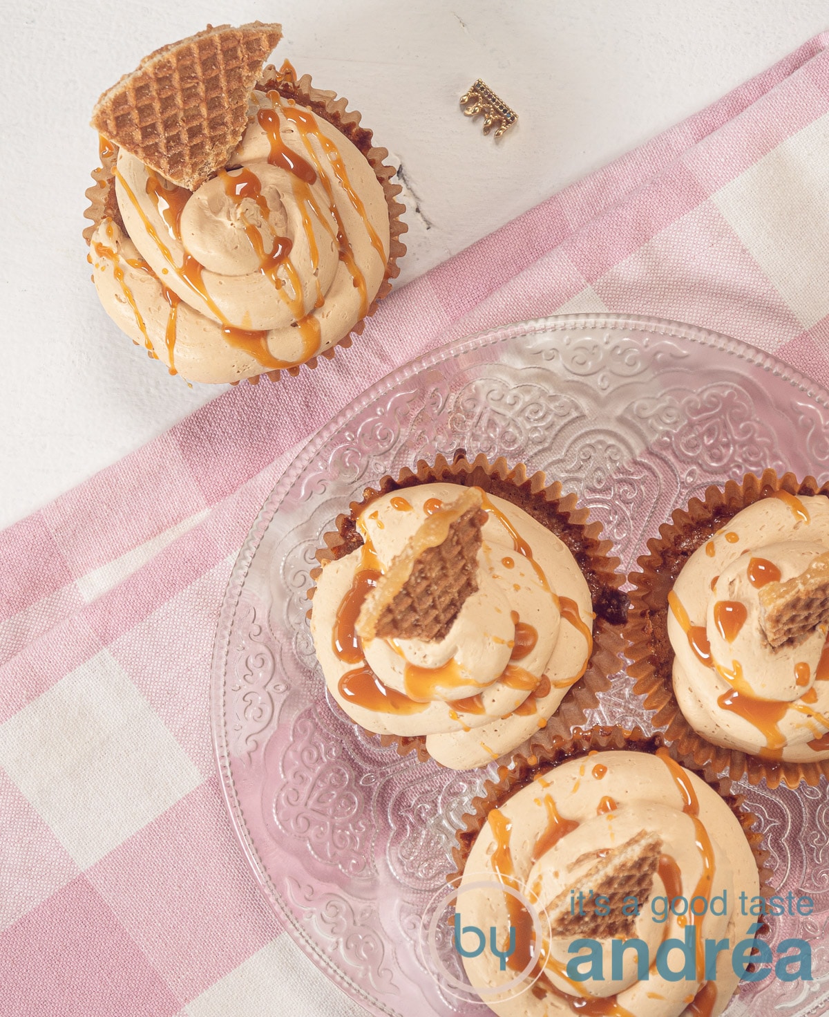 bovenaf 4 stroopwafel cupcakes met karamel en roze geblokte theedoek