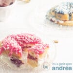 Een vierkante foto met een donut versierd met roze muisjes en een halve donut versierd met blauwe muisjes