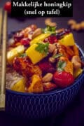 Een kom met honing sojasaus met kip, mango en tomaten.