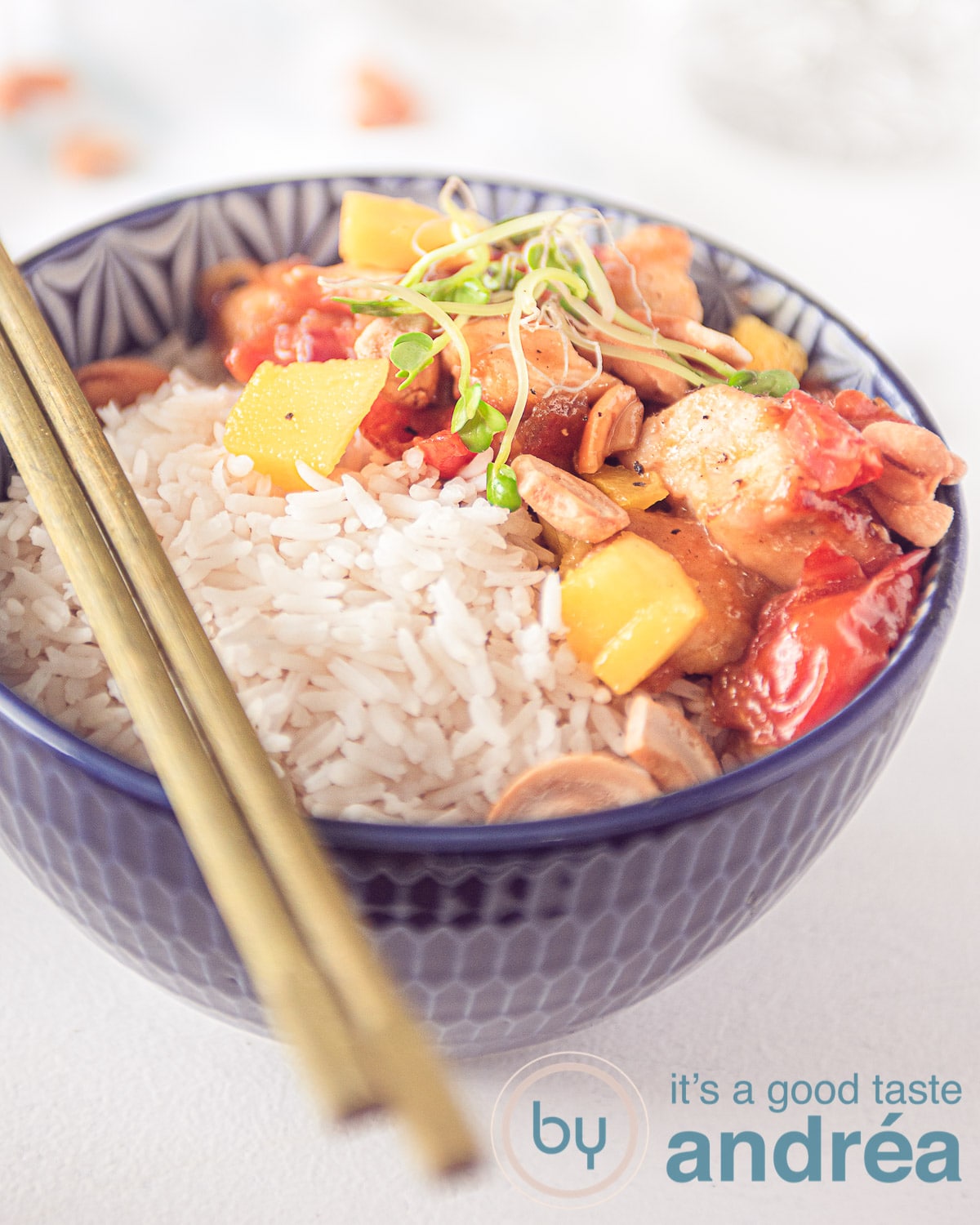 een kom met rijst en honingkip, mango en cashew noten