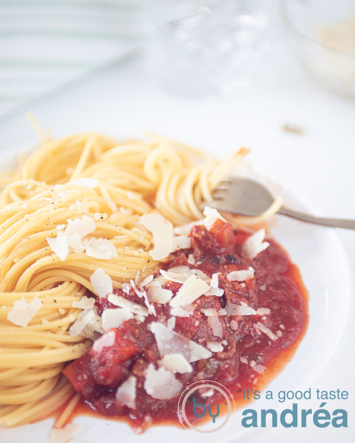 slowcooker pasta sauce with ground beef on a white plate with some spaghetti