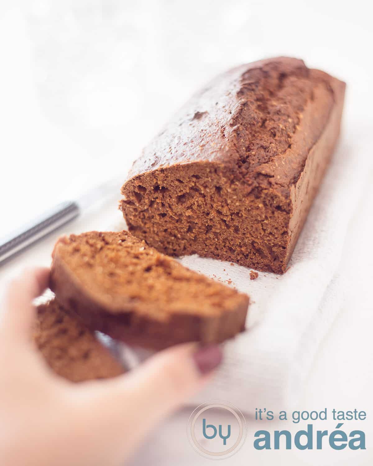 Ontbijtkoek op een wit doek waar een plakje van af is gesneden.