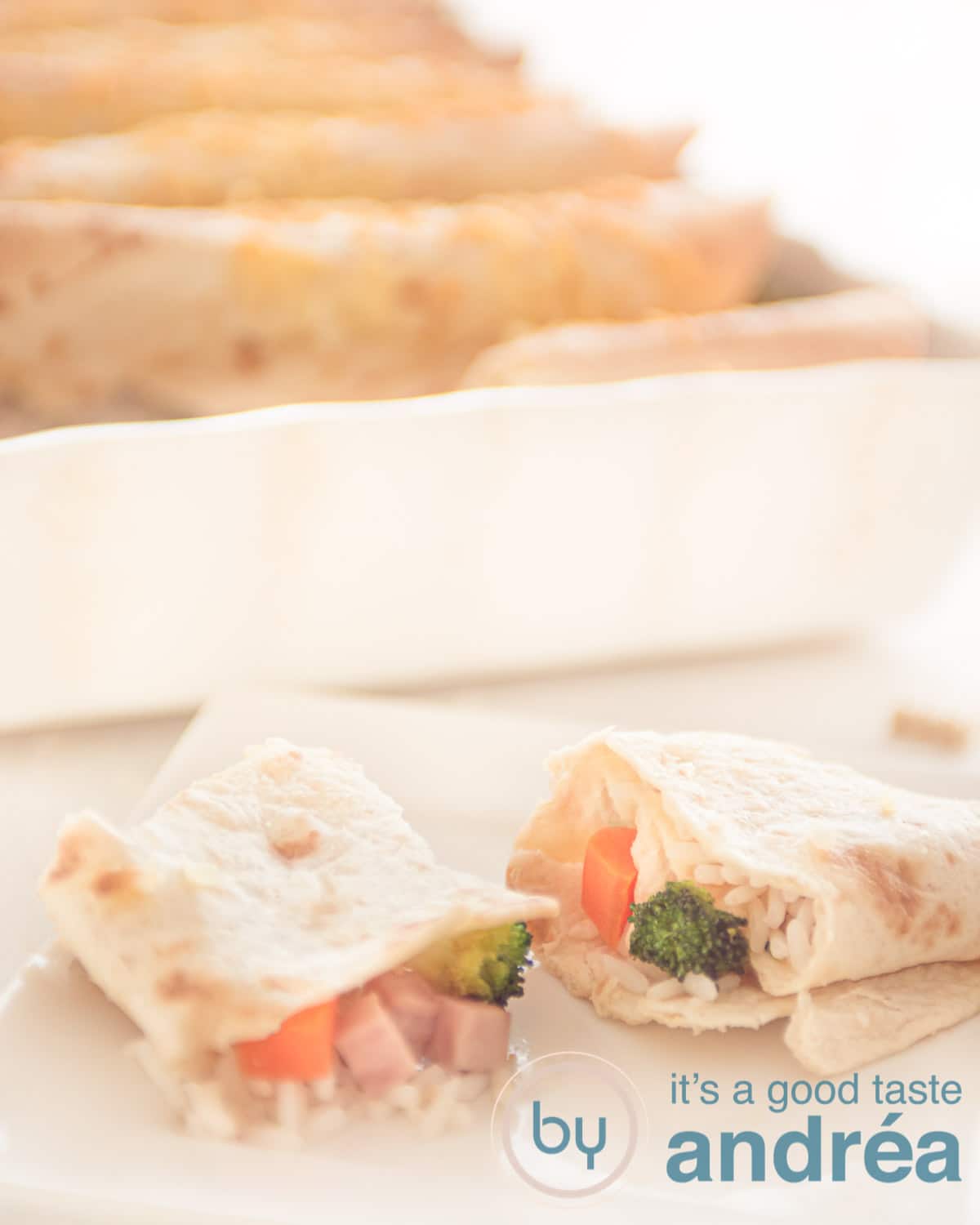 Two half wraps filled with rice, carrots, broccoli and ham and a casserole in the background