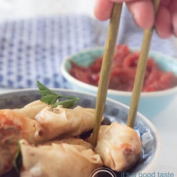 Eetstokjes die een mini loempia uit het schaaltje pakken