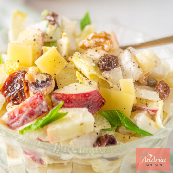 Close-up van witlofsalade met appel, kaas, walnoten en rozijnen