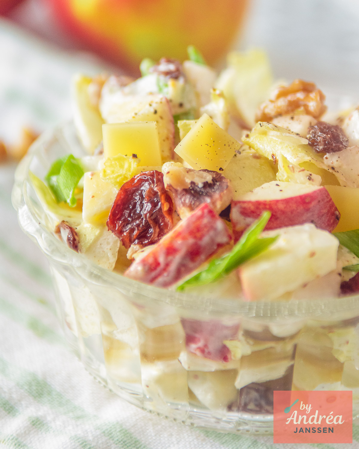 Glazen schaaltje met witlofsalade, appel, kaas, walnoten en rozijnen