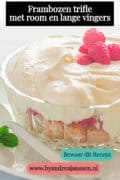 Een deel van een glazen schaal gevuld met lange vingers, frambozen en room. Een tekst: frambozen trifle met room en lange vingers.