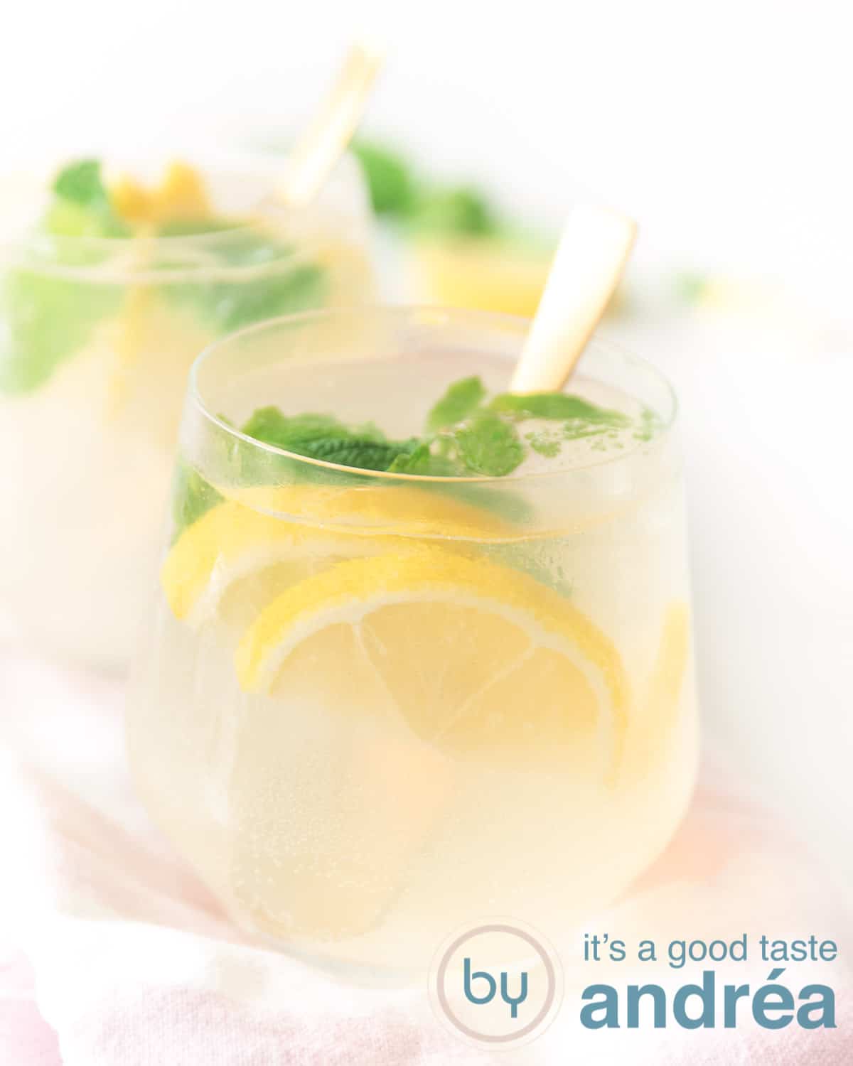 Twee glazen achter elkaar gevuld met een cocktail van limoncello en gin
