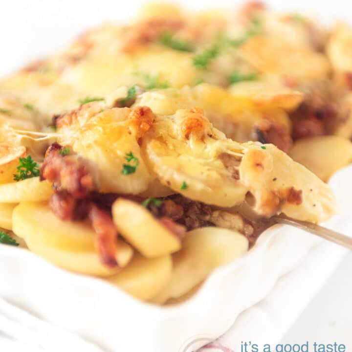 Een lepel pakt een hap aardappel anders uit de ovenschaal.