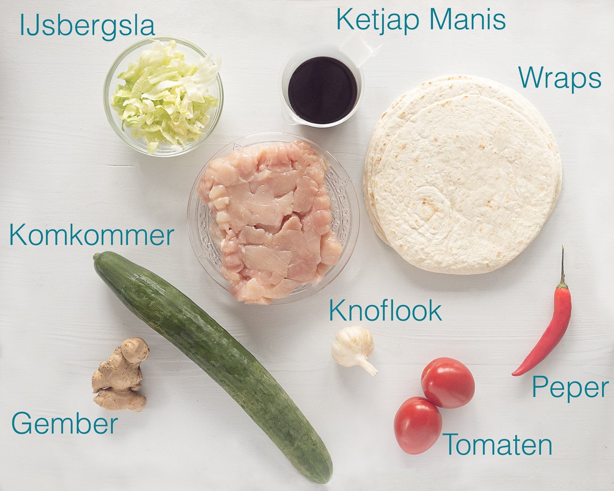 Ingrediënten voor wraps met ketjapkip op een witte achtergrond