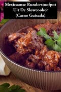 Een deel van een kom gevuld met carne guisada. Een tekst: Mexicaanse Runderstoofpot Uit De Slowcooker (Carne Guisada)