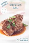 Een wit bord met biefstuk Bali in een rijke jus gegarneerd met peterselie. Een tekstoverlay beschrijft de foto: biefstuk bali, wereldkeuken, veel smaak, makkelijk recept