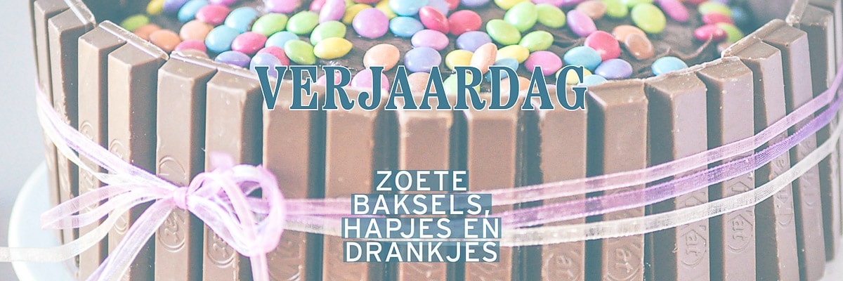 Een deel van een smarties kitkat taart met een tekstbeschrijving verjaardag, zoete baksels, hapjes en drankjes